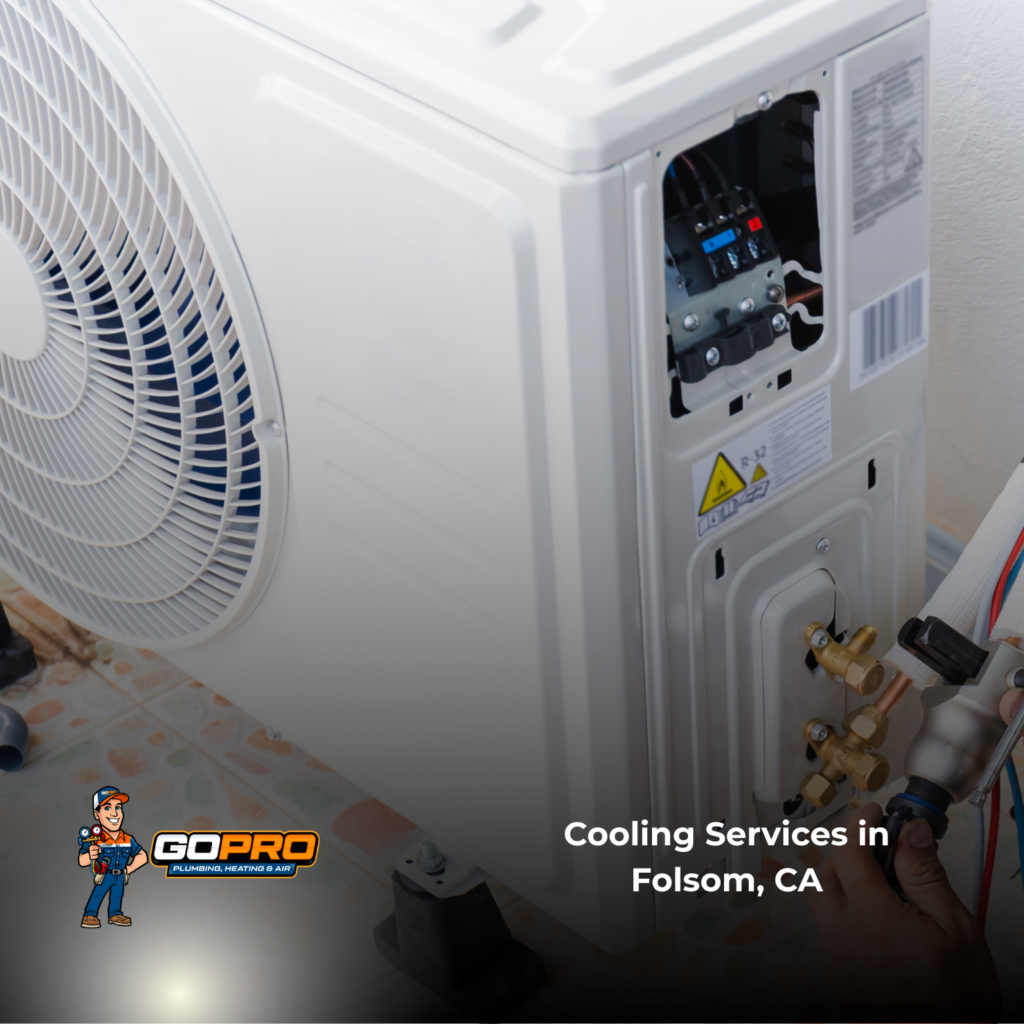 Close-up of a white outdoor air-conditioning unit with exposed wiring and brass pipe connections, labeled “Cooling Services in Folsom, CA”; the scene feels practical and technical.